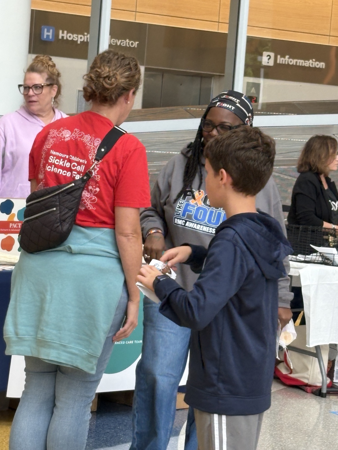 Community members learning at an outreach table